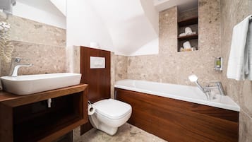 A modern bathroom with a freestanding sink, a built-in toilet, and a freestanding bathtub.