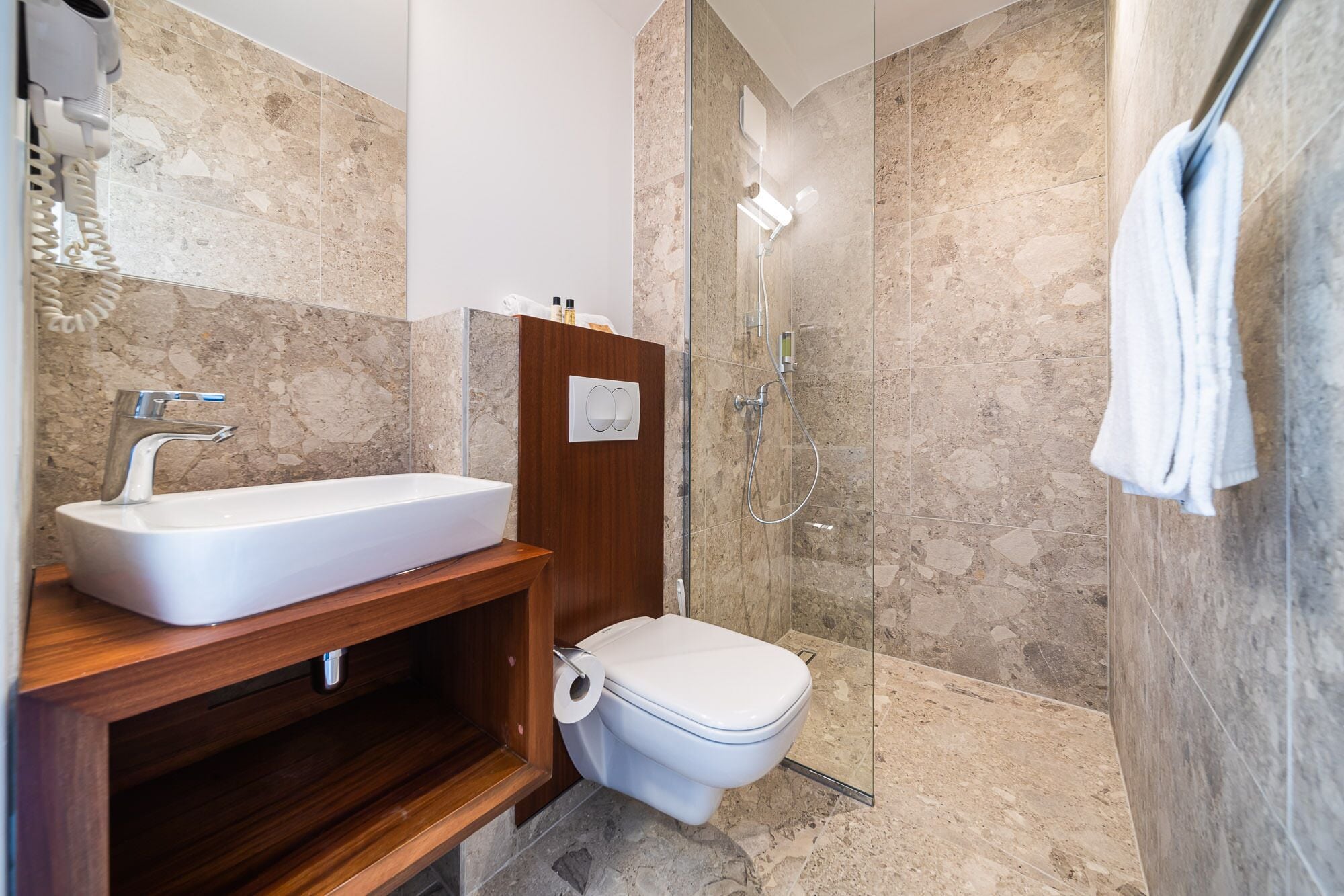 Un bagno moderno con un lavabo rettangolare, un water e una cabina doccia in vetro.