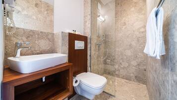 Un bagno moderno con un lavabo rettangolare, un water e una cabina doccia in vetro.