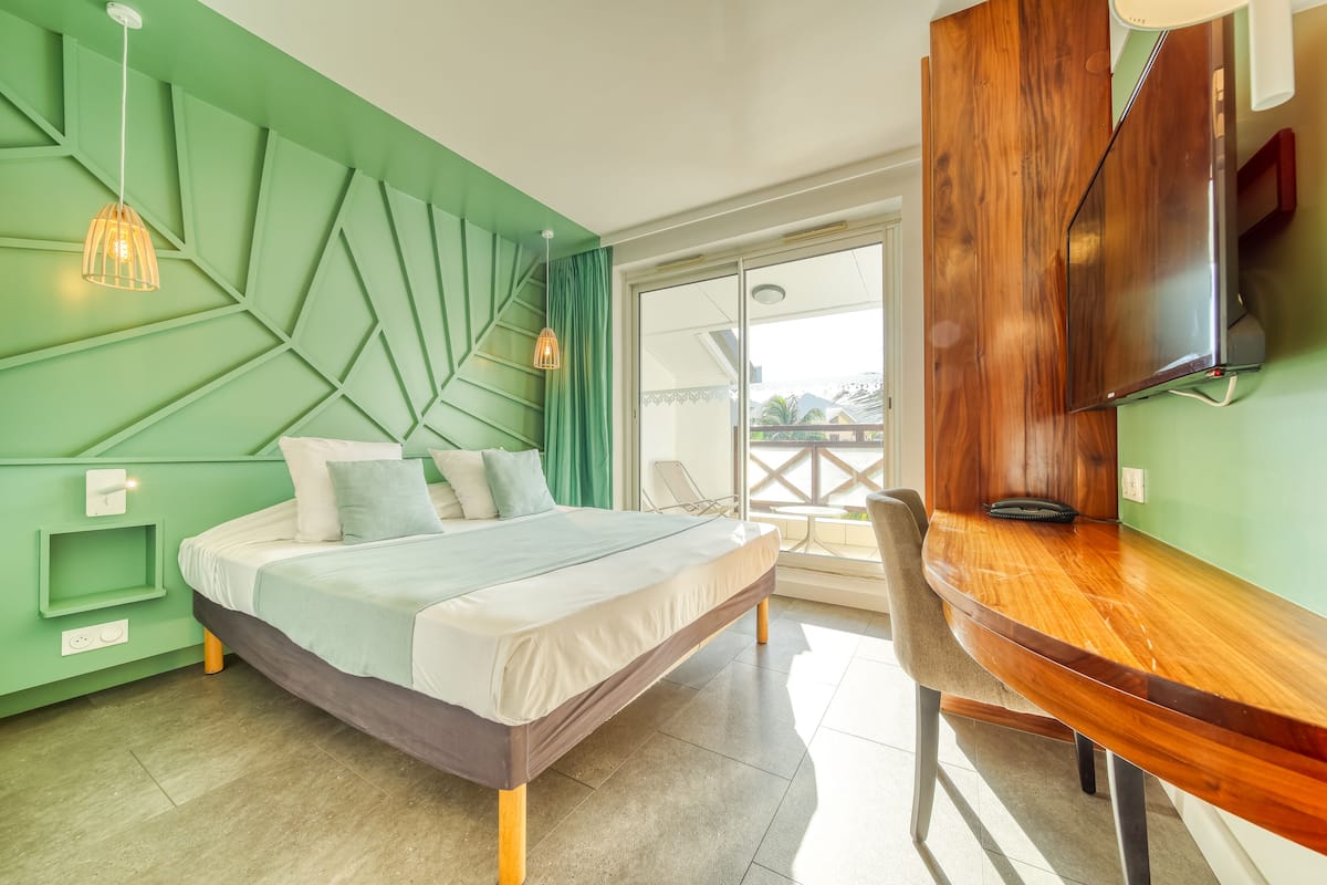 Un dormitorio moderno con una cama, un escritorio de madera y un televisor.