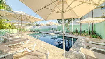 Una piscina al aire libre, una piscina climatizada, sombrillas