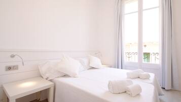 Una habitación de hotel con una cama grande, una mesita de noche y una ventana con cortinas.