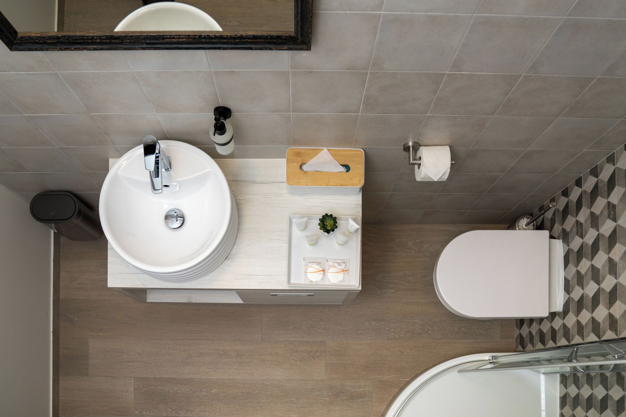 Un baño moderno con lavamanos, inodoro y ducha blancos.