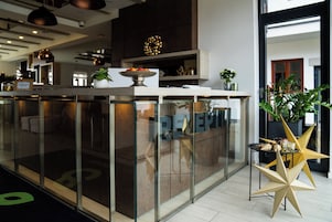 Una moderna zona de recepción con un separador de vidrio, un mostrador de recepción y una mesa decorativa en forma de estrella.