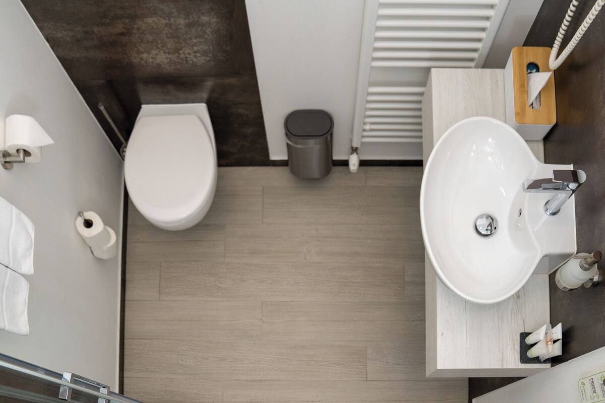A modern bathroom with a toilet, sink, and shower.