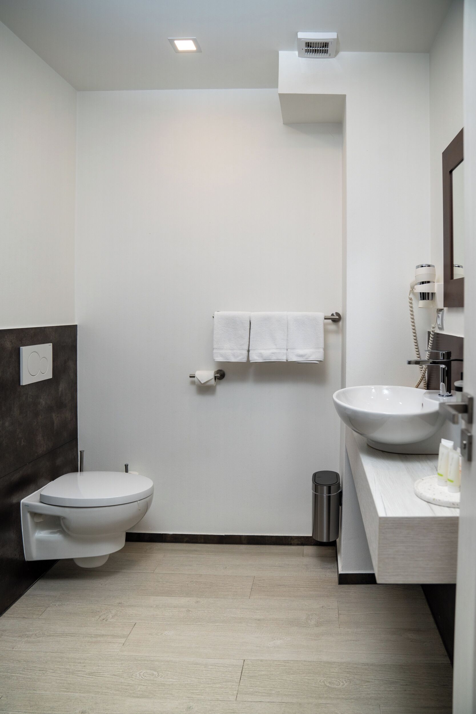 Un baño moderno con inodoro, lavabo y toallero.