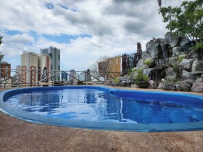 Ein Schwimmbecken mit Stadtkulisse im Hintergrund.
