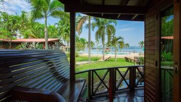 Un banco de madera con vista a una playa y palmeras.