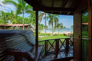 Un banco de madera con vista a una playa y palmeras.