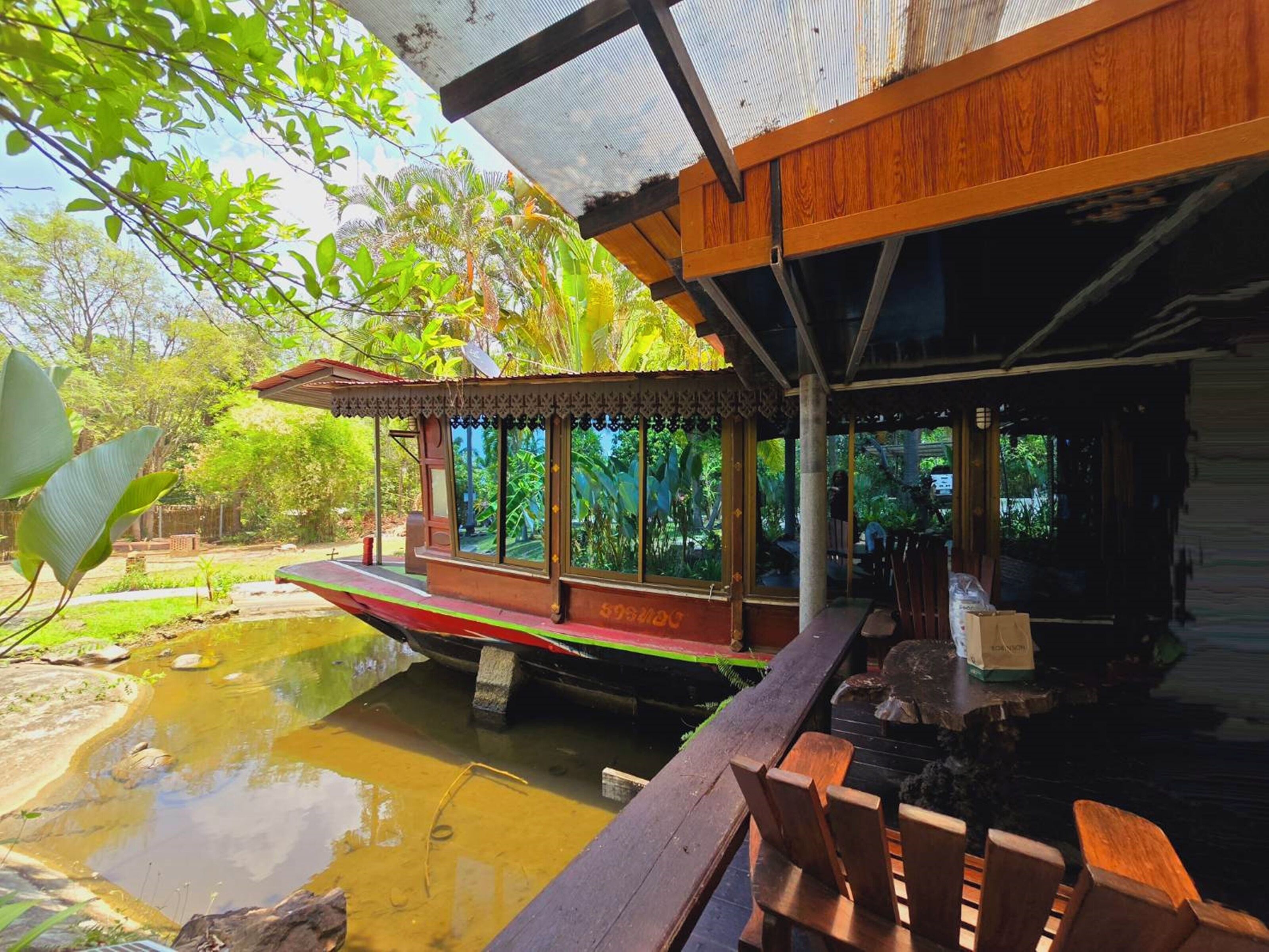 Un casero de barcos tradicional con terraza de madera y zona de estar cubierta.