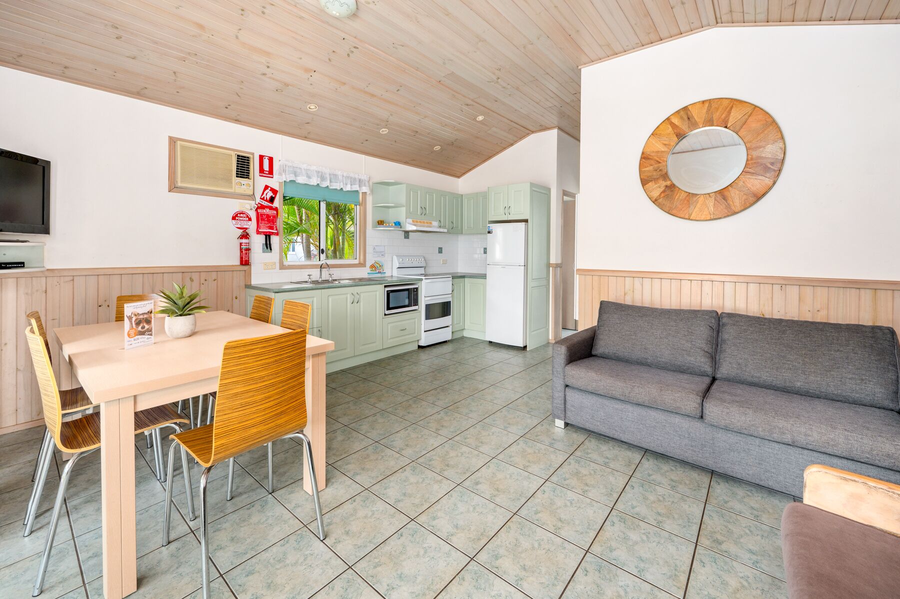 A compact living space with a dining area, kitchenette, and seating area.