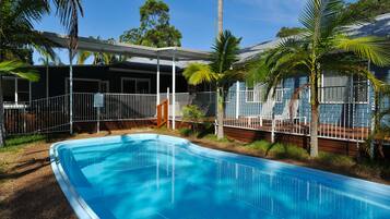 Una piscina al aire libre, tumbonas