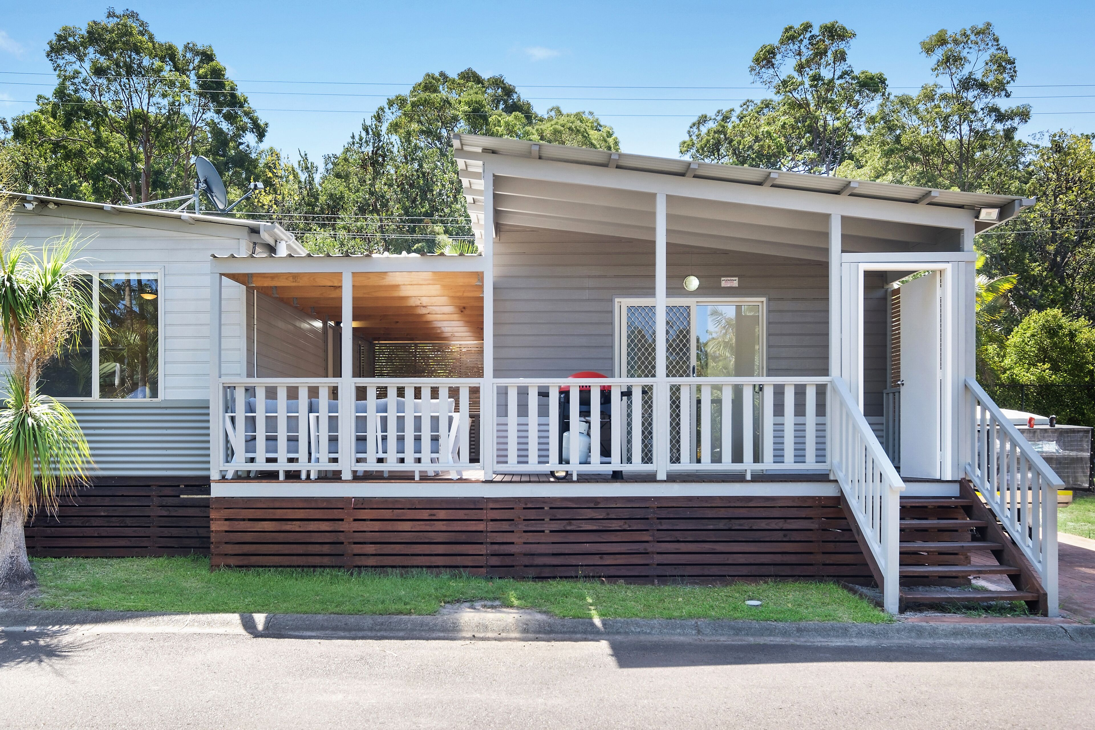 A two-story house with a covered porch and a small deck.