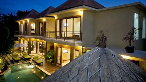 A two-story resort with a swimming pool, outdoor seating, and a thatched roof. - O Villas (Keroboken Kelod)