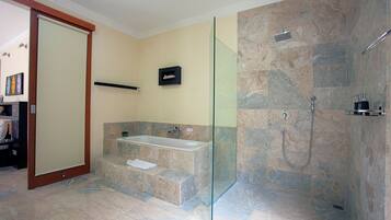 Un baño moderno con ducha de vidrio, una bañera independiente y suelo de mármol.