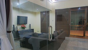 A modern living room with a glass partition, a flat-screen TV, a sofa, and a ceiling fan. - O Villas (Keroboken Kelod)