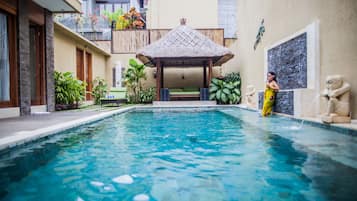 Una piscina al aire libre, sillones reclinables de piscina