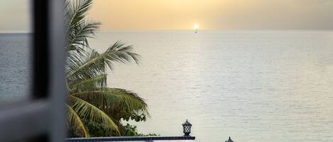 Une vue sur une piscine avec un coucher de soleil en arrière-plan.