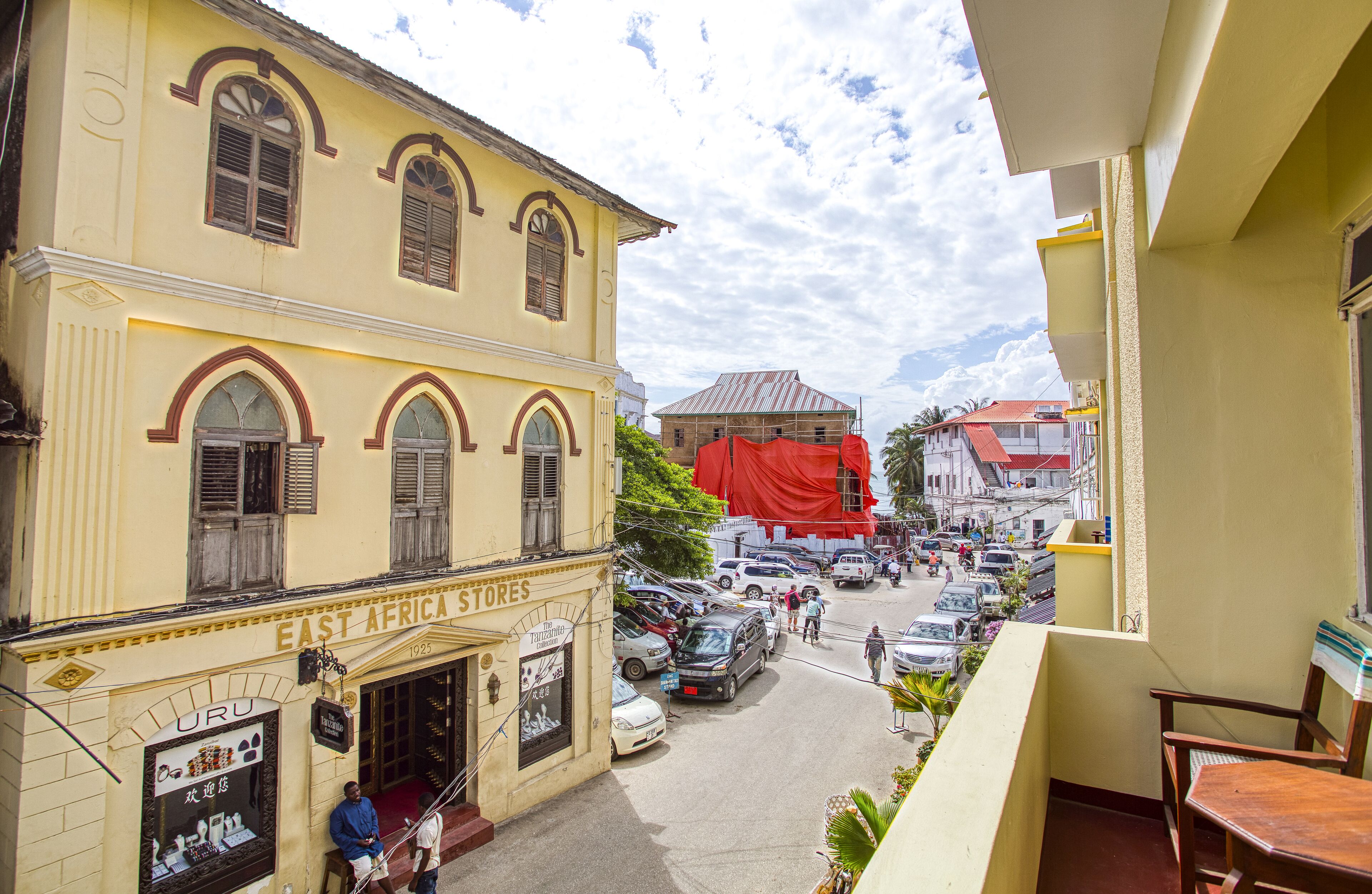 A street view with a yellow building labeled "EAST AFRICA STORES" and a red construction site in the background.