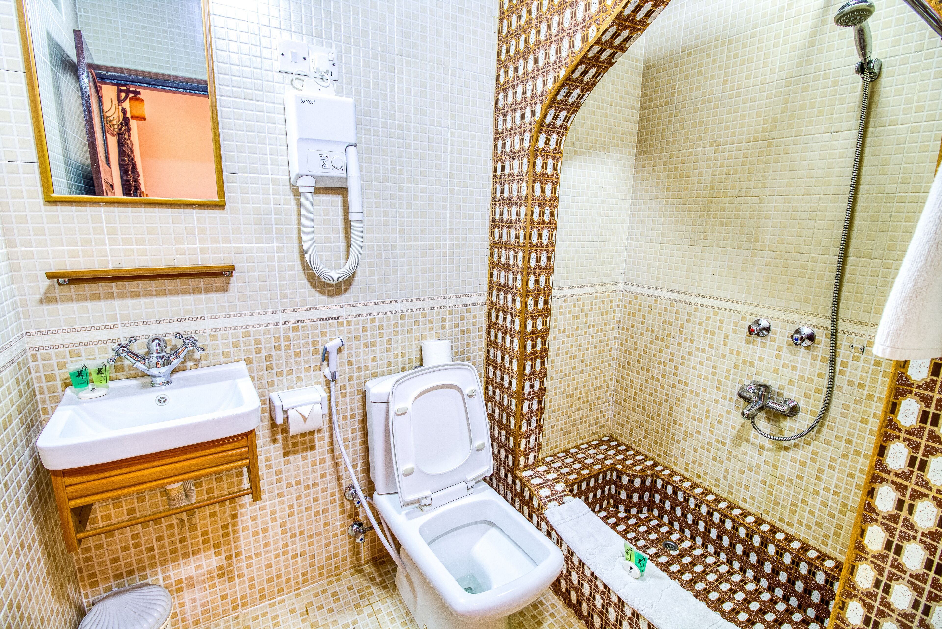 A bathroom with a toilet, sink, and shower.
