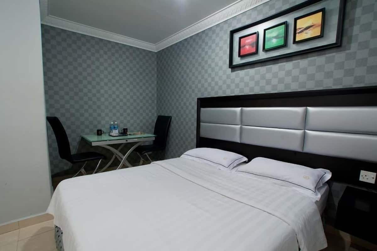 Una habitación de hotel con cama, escritorio y sillas.
