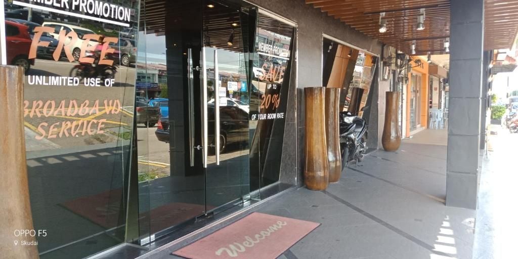 A storefront with a glass door, a welcome mat, and a sign offering free broadband service.
