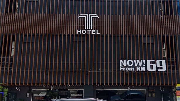Ein modernes Hotelgebäude mit einer vertikalen Holzfassade und einem gut sichtbaren Logo.
