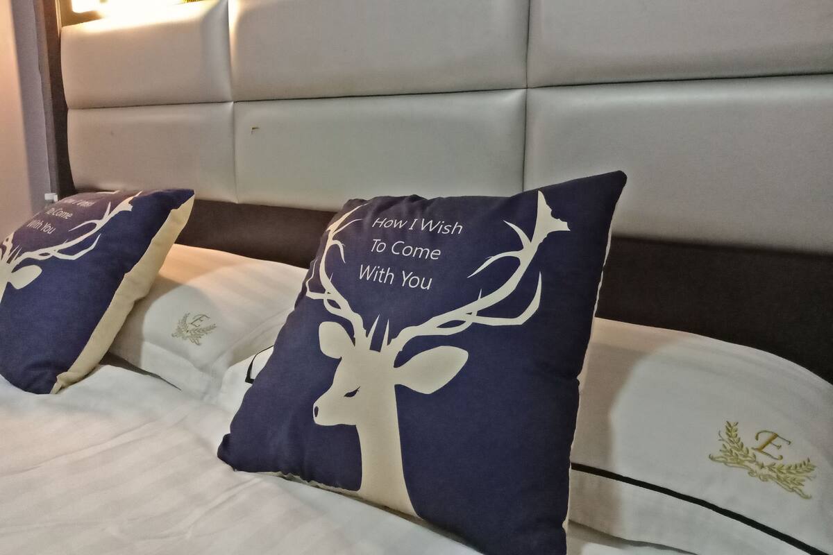 Una cama con dos almohadones decorativos con un diseño de ciervo.