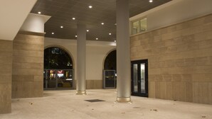 A spacious indoor area with large columns, a tiled floor, and a modern architectural design. - MyApART Suite (Rome)