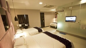 A hotel room with two beds, a television, a desk with a chair, and a mirror.