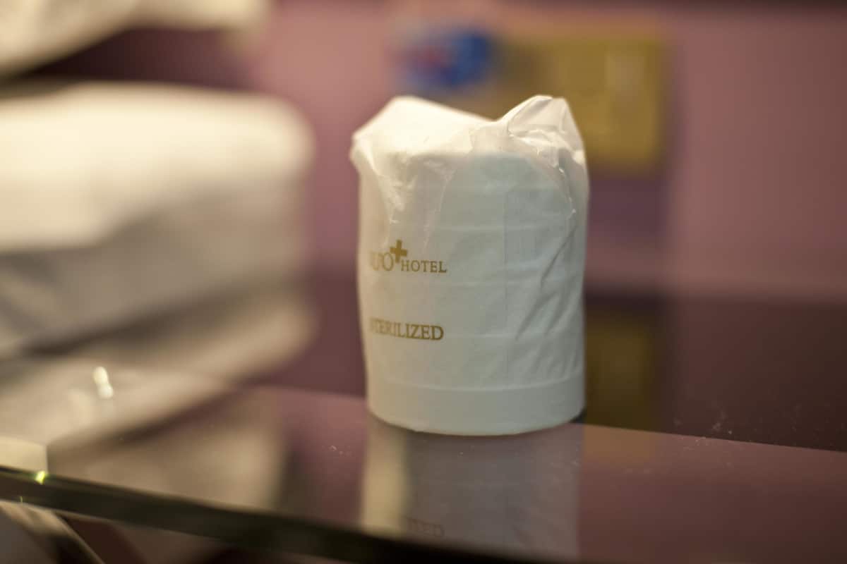 Un dispensador blanco de pañuelos de hotel con las etiquetas 