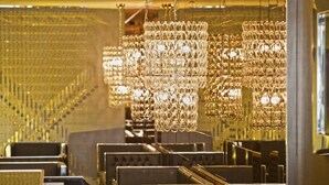 A luxurious interior with multiple seating areas and ornate crystal chandeliers.