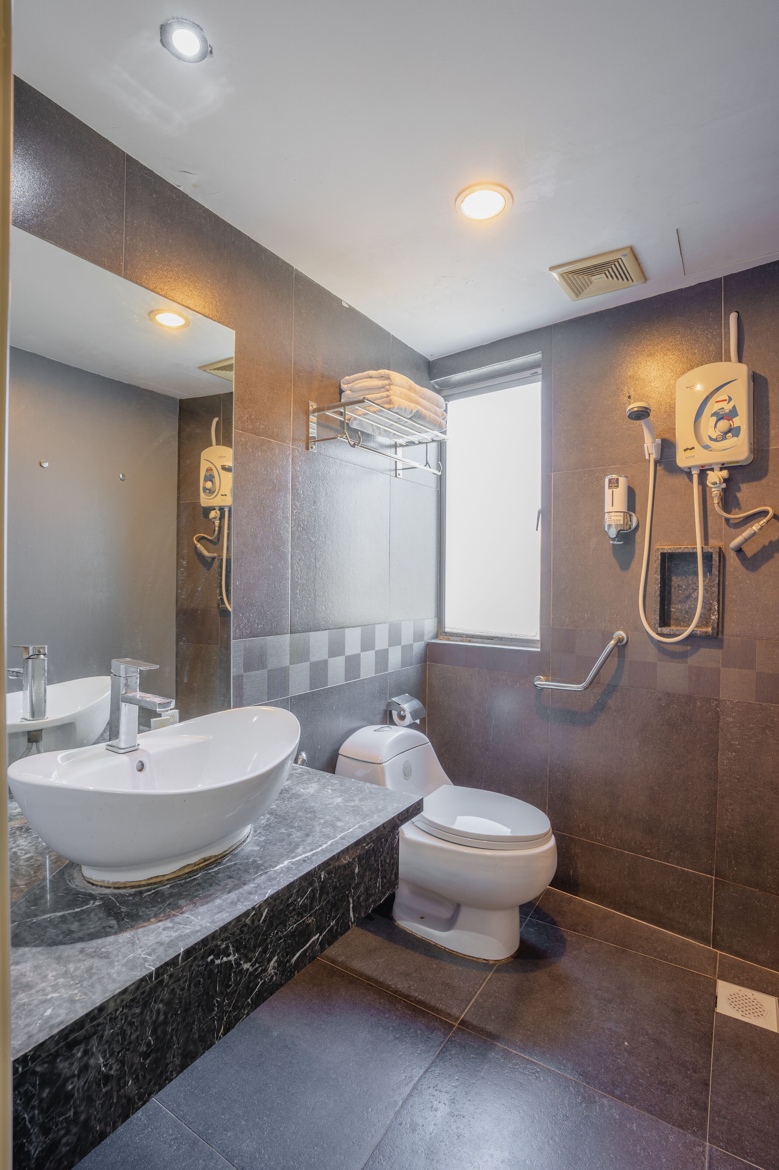 Une salle de bain moderne avec un grand lavabo, des toilettes et une douche.