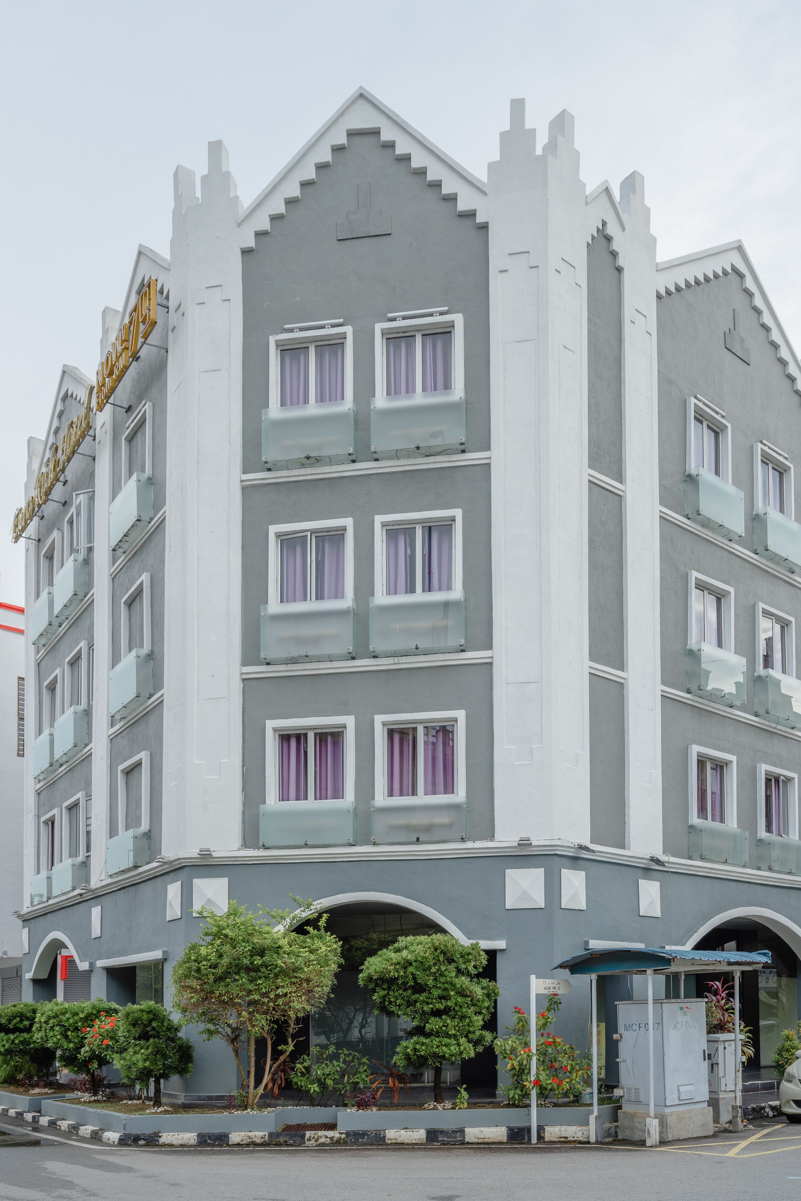 Un hôtel à plusieurs étages doté d’une architecture moderne, avec une entrée imposante, un espace d’attente abrité et un comptoir de réception bien visible.