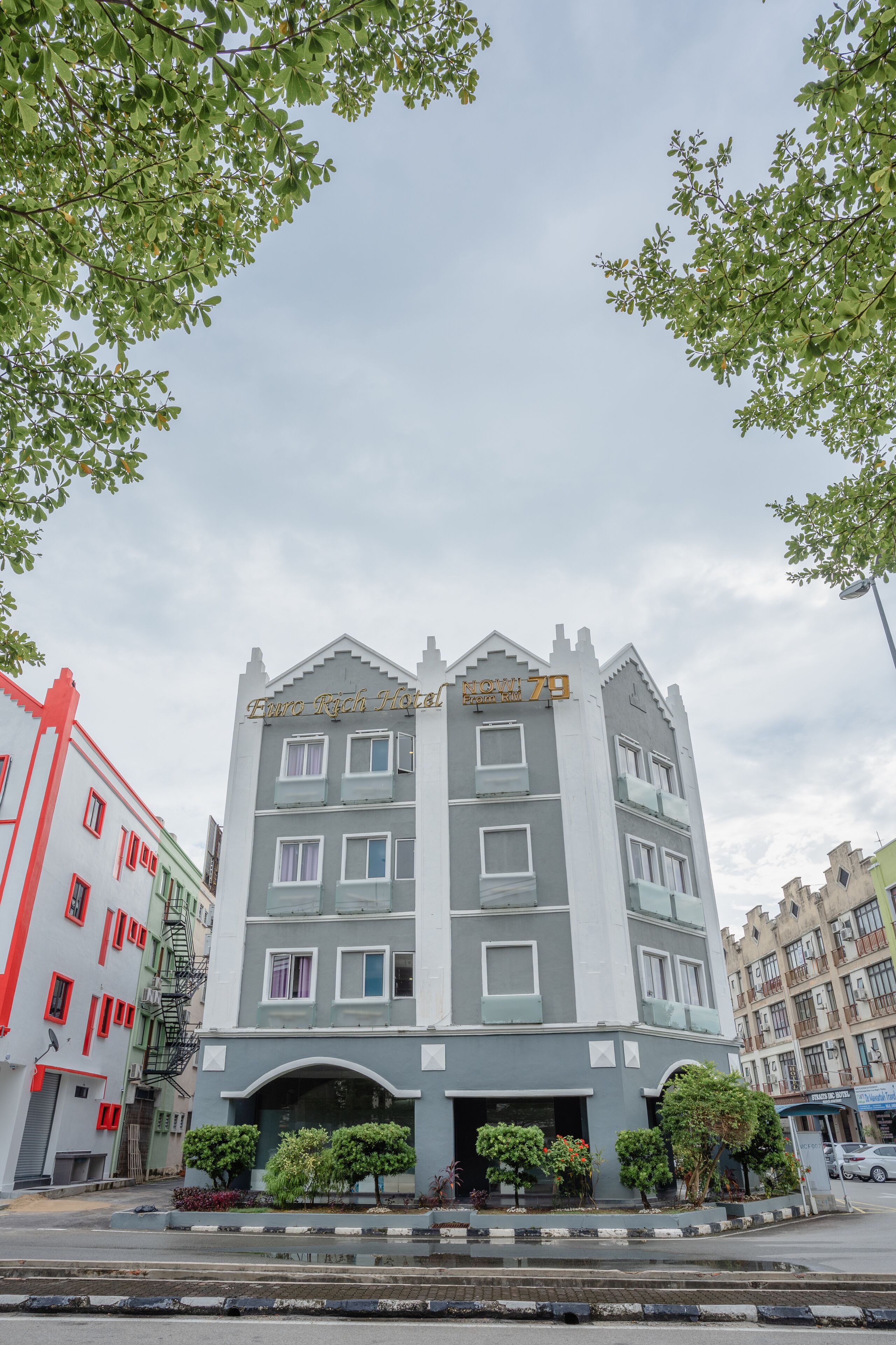 Ein mehrstöckiges Hotel mit modernem Design, das einen markanten Eingang und einen Balkon im zweiten Obergeschoss hat.