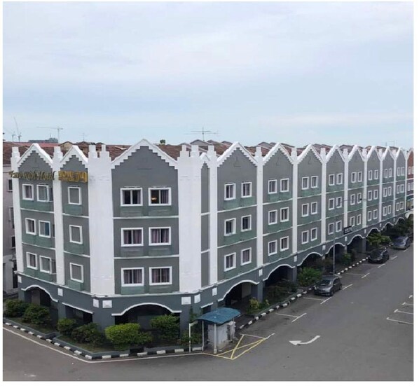 Ein mehrstöckiges Hotel mit einheitlicher Fassade, das Balkone und einen zentralen Eingang zeigt.