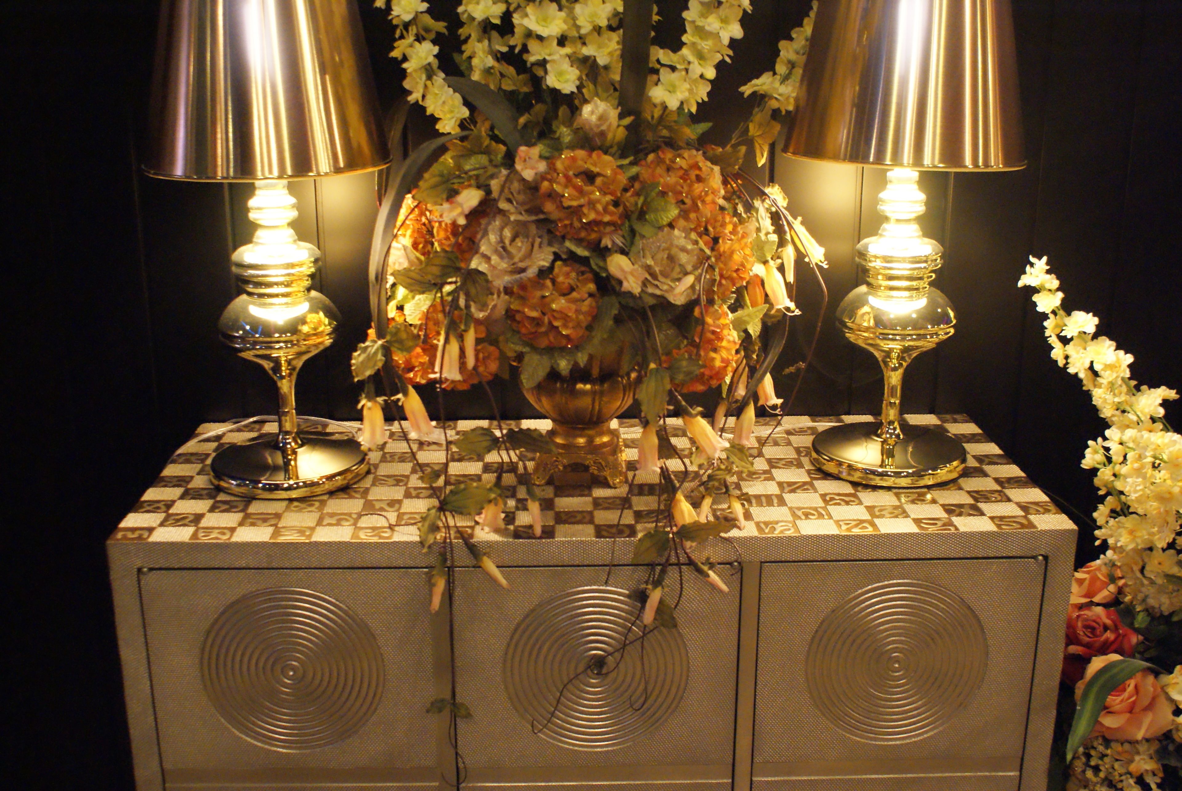 Une table avec deux lampes et un vase de fleurs.