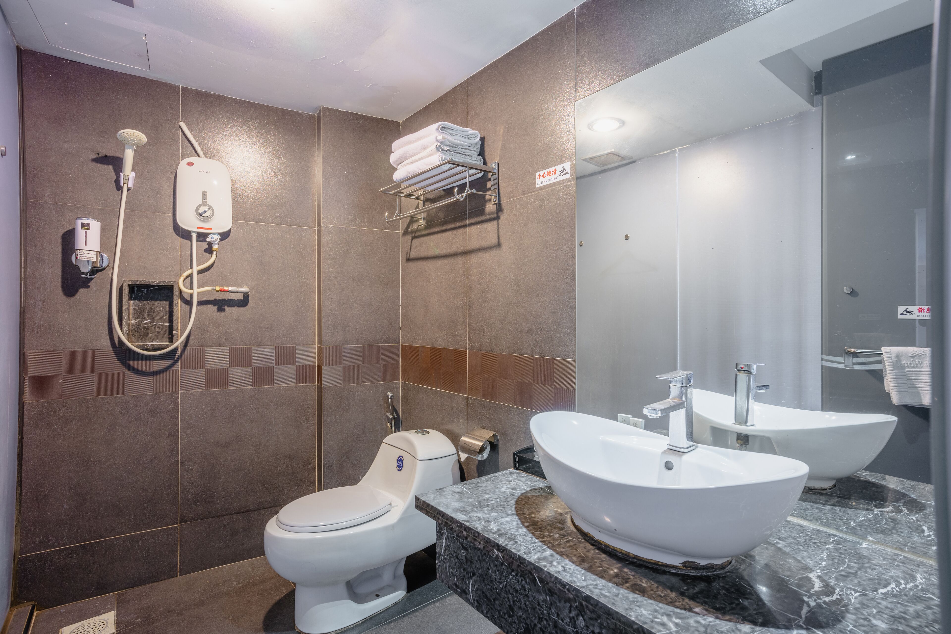 A modern bathroom with a toilet, bidet, and two sinks.