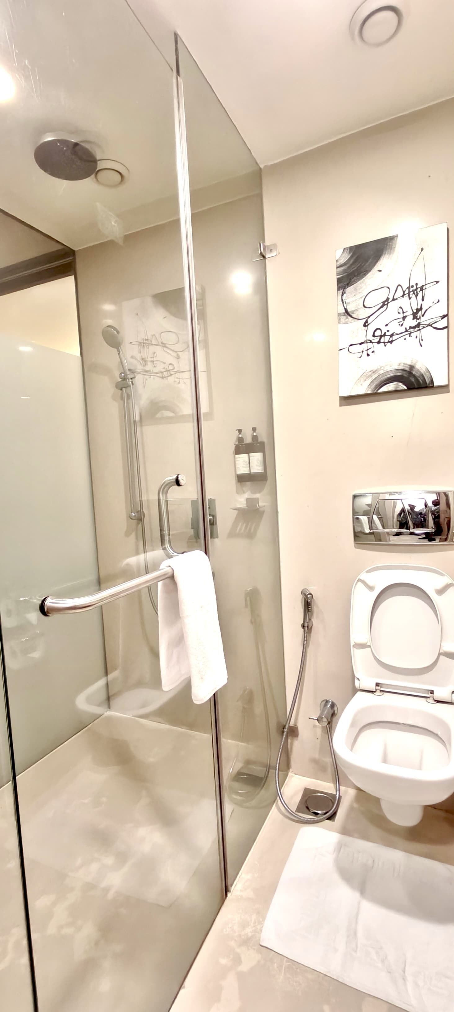Un baño moderno con ducha acristalada, inodoro y lavamanos.
