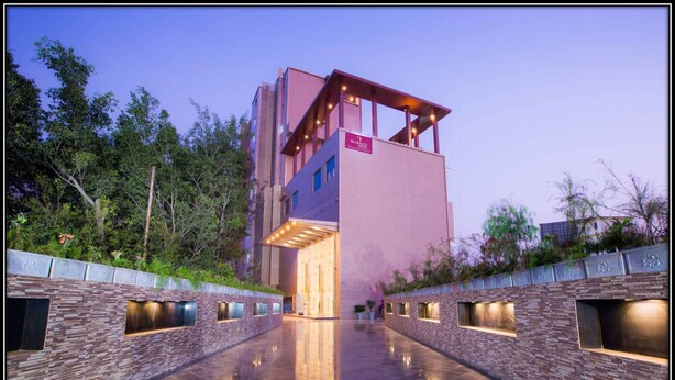 A modern building with a reflective tiled floor and a sign indicating it is a hotel. - Regenta Central Grand Exotica Pune (Pune)