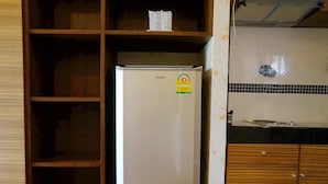 Una cocina con un refrigerador blanco, armarios de madera y salpicadero de azulejos.