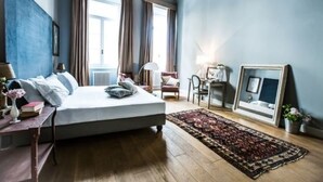 Quarto com cama, escrivaninha, cadeira, tapete e espelho.
