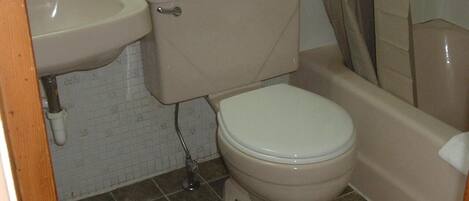 Ein Badezimmer mit Toilette, Waschbecken und Badewanne.