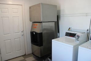 Eine Küche mit einem Edelstahl-Kühlschrank, einem Wasserspender und einer Waschmaschine.