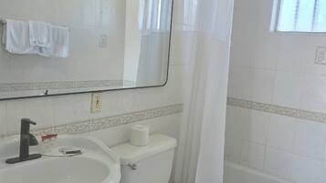 Quarto básico, 1 cama Queen | Banheiro | Chuveiro/banheira combinados, produtos de toalete grátis