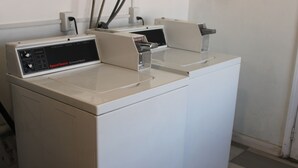 A commercial washer with a control panel and a door. - City Center Motel (Indio)