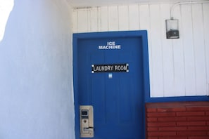 Eine blaue Tür mit der Beschriftung „ICE MACHINE“ und „WÄSCHEREI“, darüber ein kleines Schild.