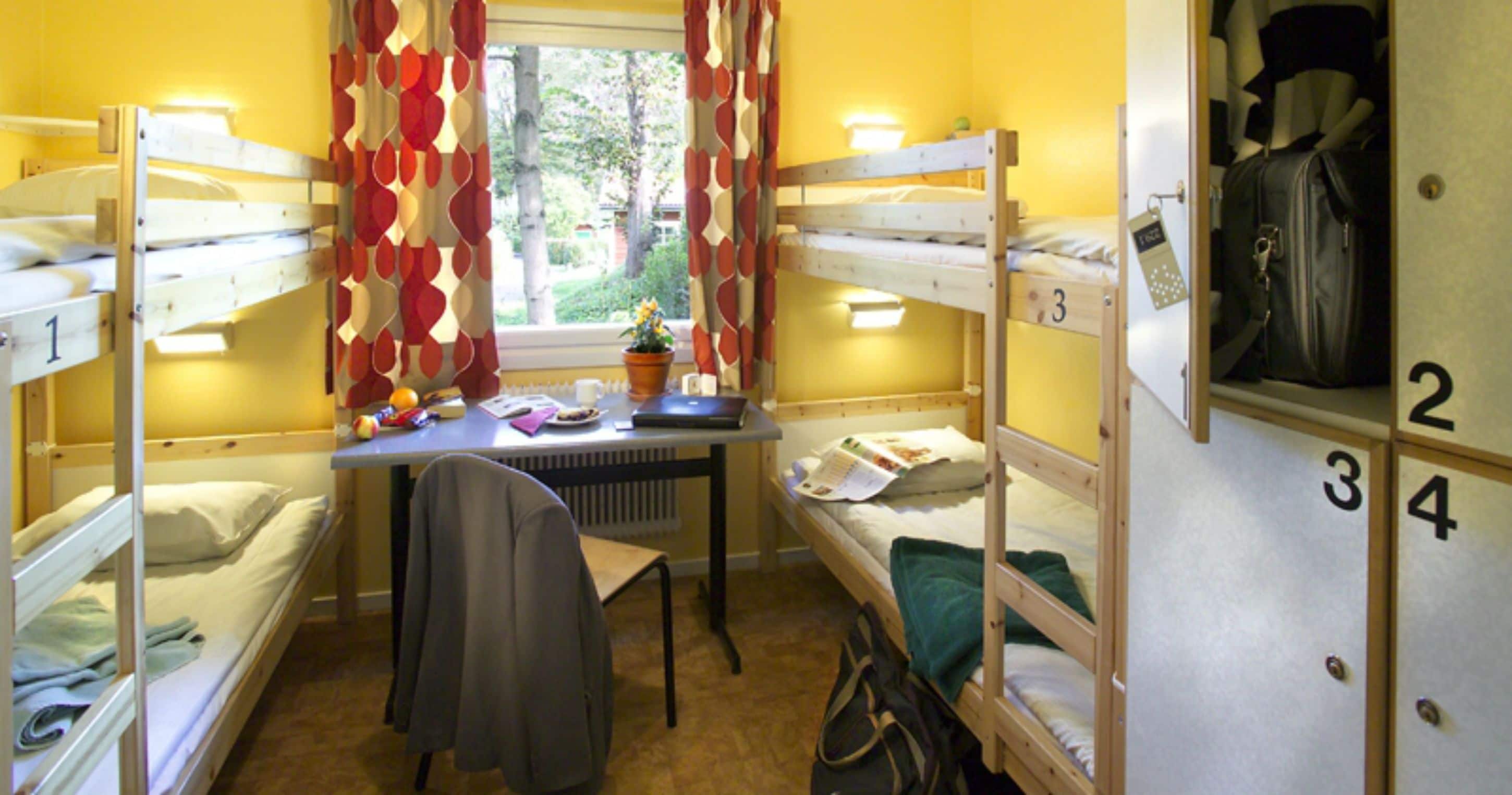 Une chambre de dortoir avec des lits superposés, un bureau, une chaise et un radiateur.