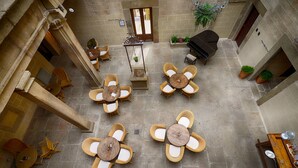 A courtyard with outdoor seating, a piano, and potted plants.