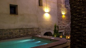 A swimming pool with a stone wall and a small window.
